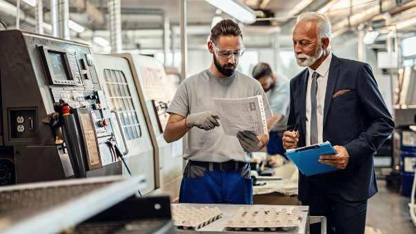 A high-level manager talking through processes with a worker.
